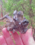 Video shows a smokey quartz cluster with very little matrix. It is blackish to dark grey in colour with translucent crystals.