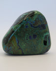 Image shows a polished piece of azurite and malachite with deep hues of blue and green in a marbled pattern.