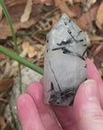 Video shows a polished milky clear quartz generator with inclusions of black tourmaline. H 7cm W 3cmo