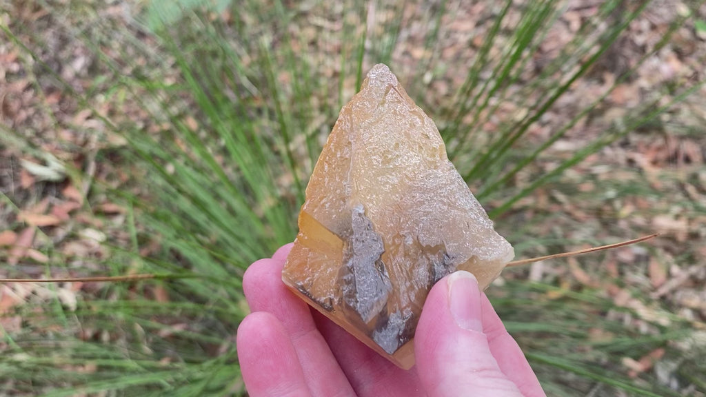 Video shows a piece of honey coloured dogtooth calcite. H 8cm W 6.5cm D 4cm