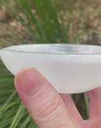 Video shows a white selenite round bowl shape. It has a shiny lustre and is 10cm in diameter