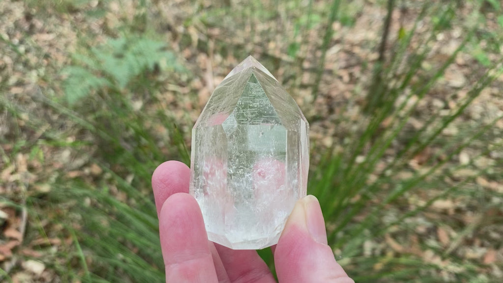 Video shows a partly polished clear quartz generator with one side unpolished which leaves a space to place your thumb. 