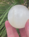 Video shows a white selenite polished sphere. white in colour with a shiny lustre. 