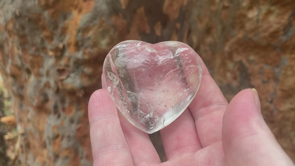 Video shows an A grade polished clear quartz heart with high clarity and lots of inclusions. 