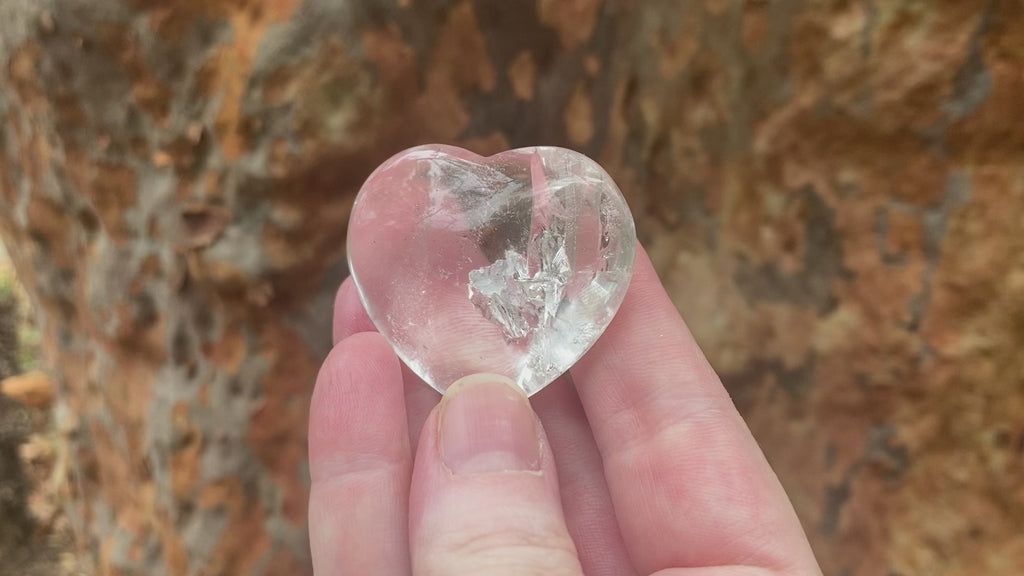 Video of a polished clear quartz heart with a small rainbow inclusion.