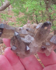 Video shows a smokey quartz cluster with very little matrix. It is blackish to dark grey in colour with translucent crystals. 