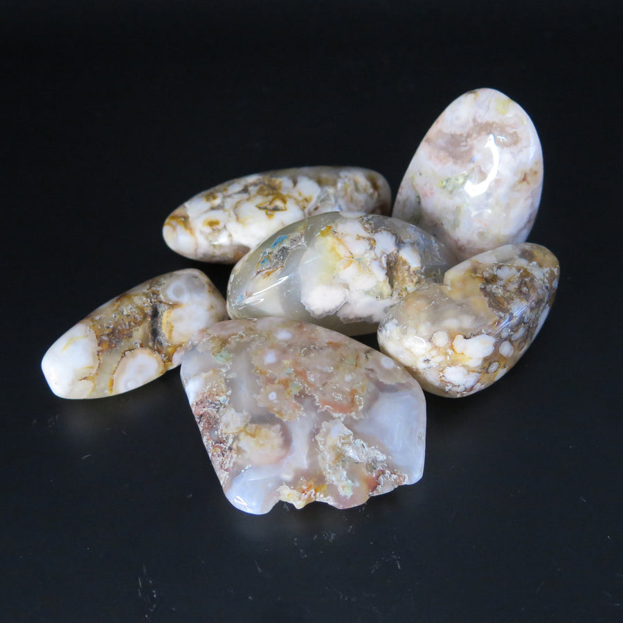 Image shows a group of flower agate polished tumble stones with various and individual patterns. 