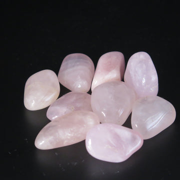 Image shows rose quartz tumble stones, soft pink in colour. 